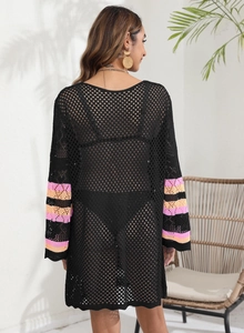 Detail of black crochet beach cover-up featuring colorful striped sleeves and mesh texture