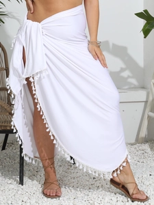 Détail d'un paréo blanc avec finitions à franges et taille nouée ajustable pour plage
