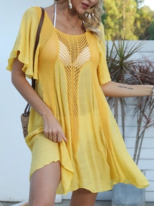 Detail of yellow crochet beach cover-up featuring deep V-neck and ruffled sleeve cuffs