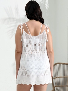 Detail of white crochet knit beach cover-up featuring delicate shoulder bow tie straps