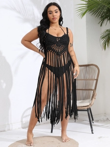 Detail of black crochet beach cover-up featuring intricate hollow patterns and long fringe