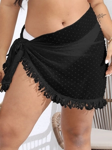 Detail of black swiss dot sarong with fringe hem and tie waist on chiffon fabric