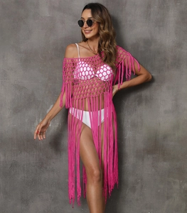 Detailed texture of rose pink crochet beach cover-up with long tassels and honeycomb mesh