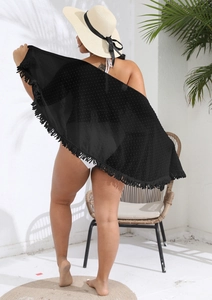 Detail of a black chiffon beach cover-up featuring fringe trim and polka dot texture