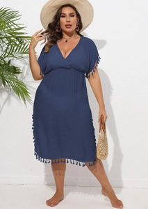 Detail of plus size navy V-neck beach dress featuring tassel trim and a textured fabric