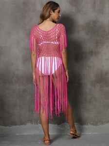 Detail of magenta crochet beach cover-up featuring hollow mesh knit and long back fringe