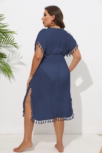 Detail of dark blue beach cover-up featuring fringe hem, side slit, and cinched waist
