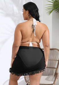 Detailed back view of a black tassel beach skirt with polka dot texture and fringe
