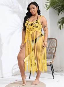 Close-up of bright yellow crochet beach cover-up with geometric hollow lace and long fringe