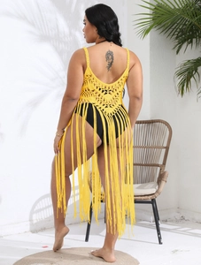 Detail of yellow crochet beach cover-up with long fringe and hollow knit texture