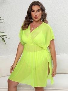 Detail of neon yellow mesh beach cover-up featuring a deep V-neck and side slit design