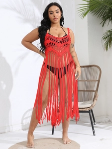 Detail of red crochet beach cover-up with hollow knit pattern and long fringe hem