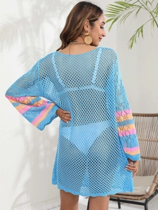 Detail of blue crochet beach cover-up featuring colorful striped sleeves and knit texture