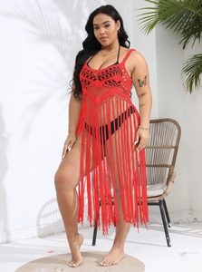 Detail of red crochet beach cover-up with long tassels and intricate knit pattern