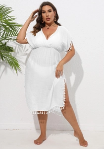Detail view of the deep V-neckline and white tassel fringe on this plus size beach dress