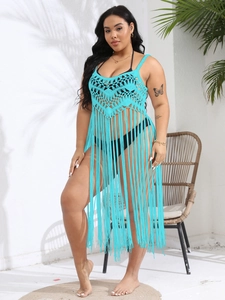 Detail of bright blue crochet beach cover-up featuring elegant long fringe hem and straps