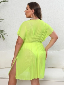 Detail of neon green sheer mesh beach cover-up featuring elastic high waist and side slit