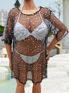 Détail de la tunique de plage en tulle noir transparent avec imprimé étoiles dorées