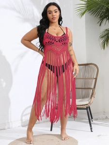 Detail of red crochet beach cover-up featuring intricate hollow knit and long tassels