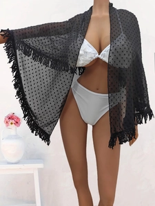 Detail of black Swiss dot mesh beach cover-up featuring fringe hem and wrap design