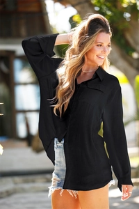 Detailed texture of a black long-sleeve textured fabric shirt with chest pockets and buttons