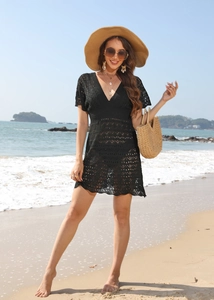 Detail of the black crochet beach cover-up showing intricate wave knit and V-neckline