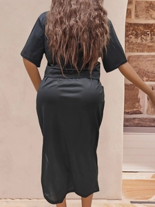 Elegant black satin maxi beach dress with open back and split, shown from a rear perspective