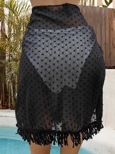 Detail of black Swiss dot mesh beach sarong featuring elegant fringe hem and sheer texture