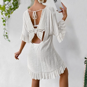 Détail d'une robe de plage blanche bohème avec papillon en crochet au dos et lien à nouer