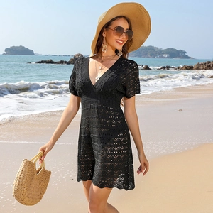 Detail of black crochet beach cover-up featuring deep V-neck and wave hollow pattern