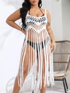 Close-up of white crochet beach cover-up featuring intricate hollow patterns and long tassels