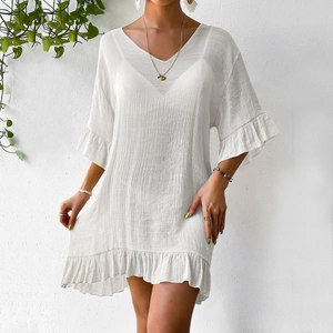 Détail de la robe de plage blanche à col en V avec tissu texturé et manches évasées