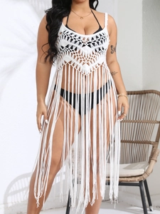 Detail of white crochet beach cover-up featuring intricate mesh and long fringe tassels