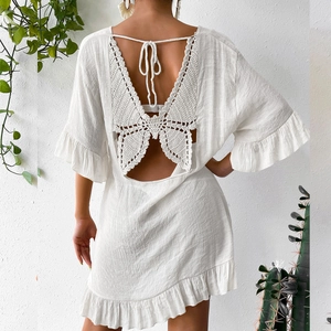 Vue arrière d'une robe de plage blanche avec papillon en crochet et dos nu à nouer