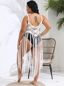 Back view of a white crochet beach cover-up featuring long tassels and geometric openwork