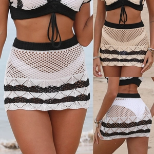 Close-up detail of crochet knit beach skirt with contrast wave hem and openwork mesh pattern
