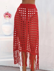 Detalle de falda roja de ganchillo calada con borlas y flecos de estilo bohemio chic