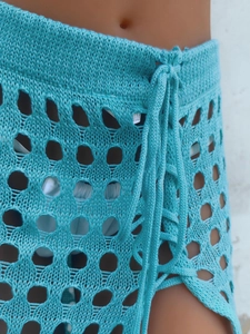 Detalle de falda de ganchillo azul claro con ojales huecos y cordón de punto tejido