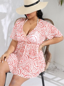Detail of plus size V-neck beach cover-up with red abstract dot print on white fabric