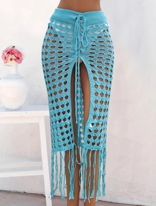 Detalle de la falda playera de ganchillo azul claro con calados de diamante y flecos