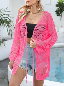 Detail of pink crochet cover-up showing hollow-out knit pattern and long tassel ties