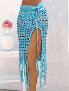 Detalle de falda de ganchillo azul lago con calados, abertura alta y flecos decorativos