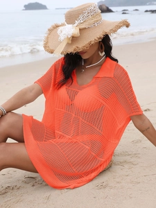 Détail de la tunique de plage en maille orange avec col en V et texture ajourée