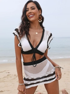 Détail d'un ensemble de plage en crochet blanc avec bordures noires contrastées et tricot