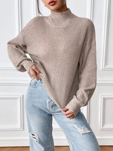 Loose fit women high neck sweater in oatmeal knit paired with blue distressed jeans