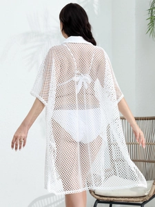 Detail of white mesh beach cover-up featuring open-knit texture and elegant collar design