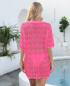 Detail of hot pink crochet beach cover-up showing intricate knit texture and hollow out design