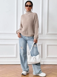 Chic beige turtleneck ribbed knit sweater styled with blue jeans and white handbag