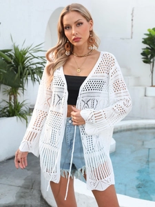 Detailed view of white crochet cover-up featuring intricate geometric patterns and tassel ties