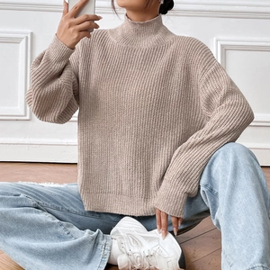 Close-up of mock neck knit sweater featuring thick ribbed texture and drop shoulders